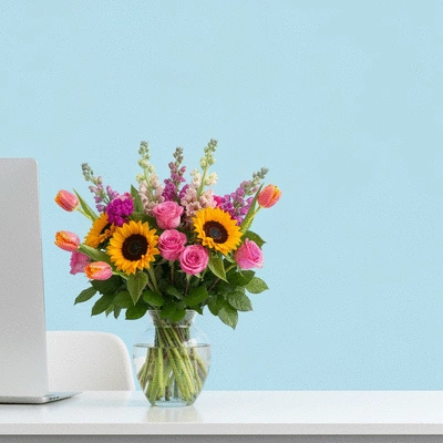 Professional floral arrangement on an office desk, vibrant colors, clean background